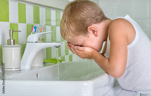  Boy wash the face in the bathroom.The beginning of a new day