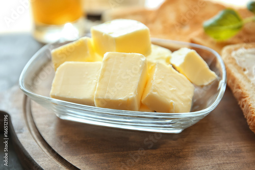 Glass bowl with cubes of butter on cutting board