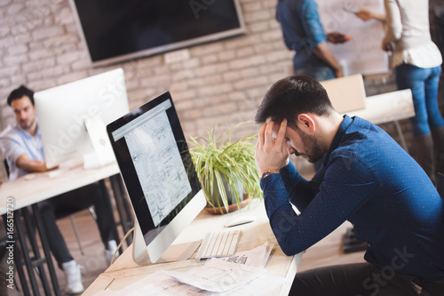 Overworked exhausted office employee working at office photo