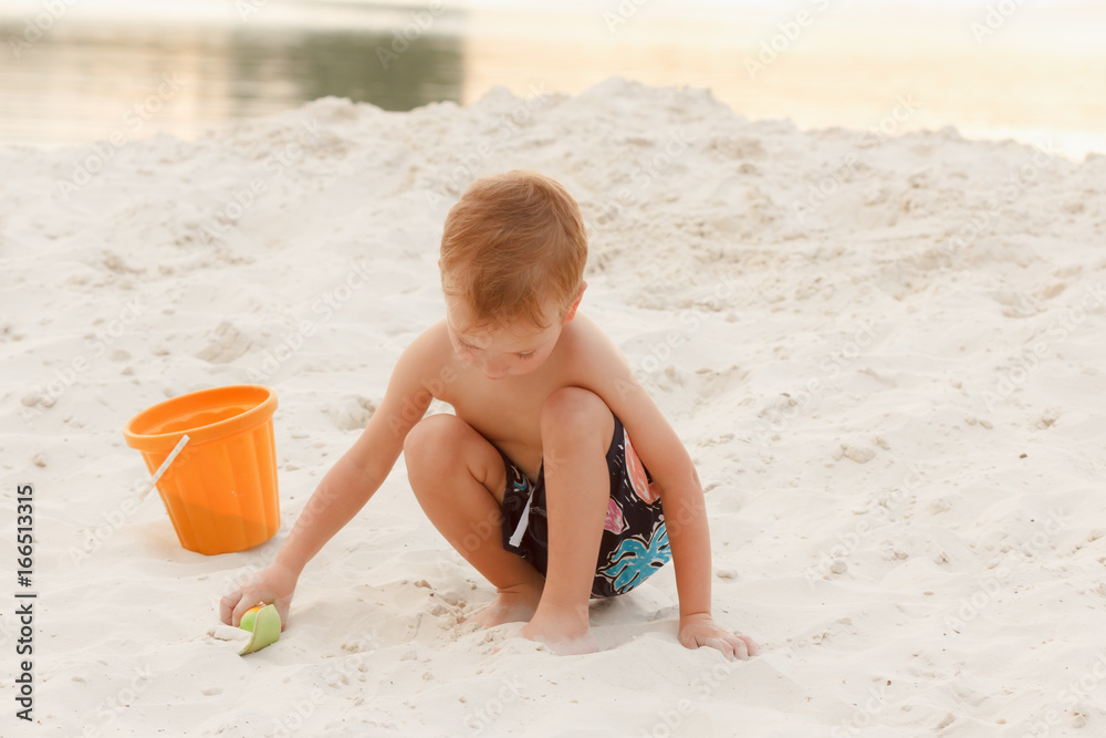 Little boy resting on a sandy beach Little boy resting on a sandy beach