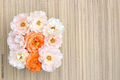 Pink and orange roses on a straw napkin