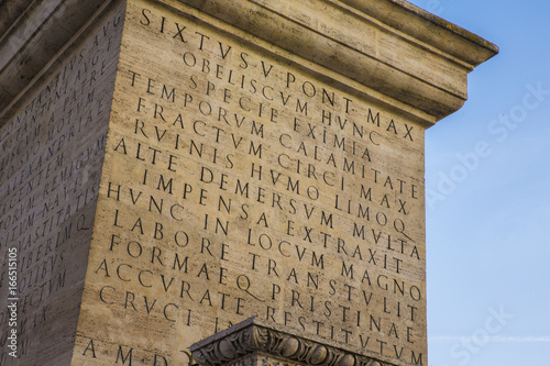 Dettaglio di un'iscrizione in latino e risalente agli antichi romani, ora su un obelisco situato a Roma. La base è di marmo e la scrittura traiana. photo