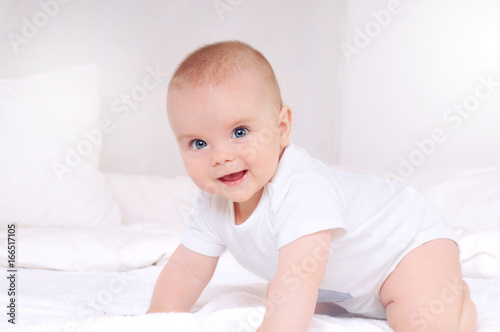 Newborn baby smiling and looking at camera