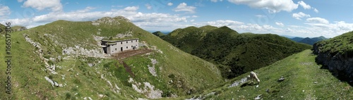 panorama with abandoned barracks below of summit of Slatnik in Julian Alps in Slovenia photo