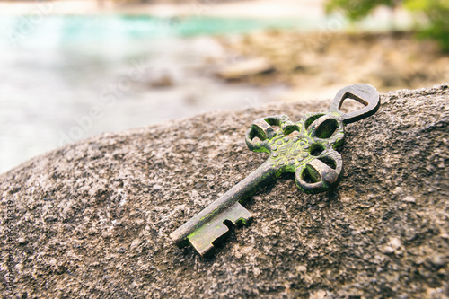 Treasure key lost on rock at the beach. Opportunity or Mystery concept. photo