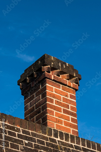Detail of rooftop red brick chimney in Tudor architecture