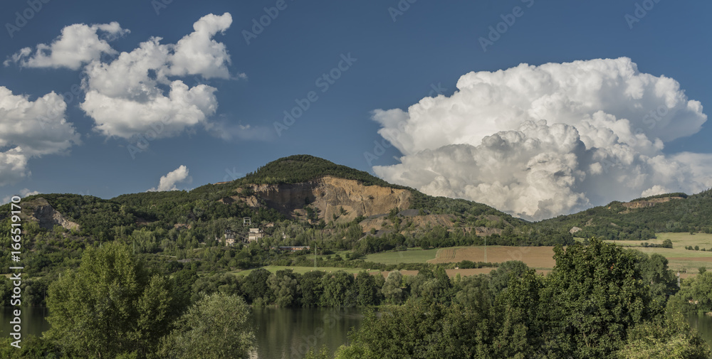 Quarry on hill near Libochovany village with big white clouds