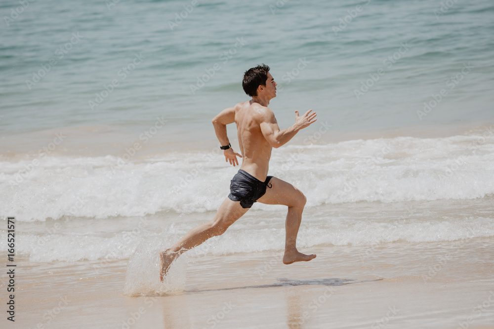 Fit young man running work out at the beach summer Fit young man running work out at the beach summer