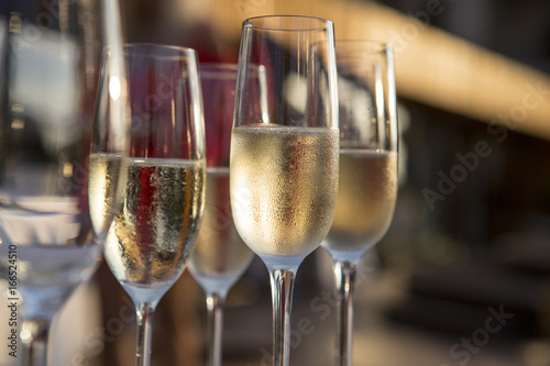 A lot of wine glasses with a cool delicious champagne or white wine at the bar. Alcohol background. lot of glasses with champagne during on the party table.