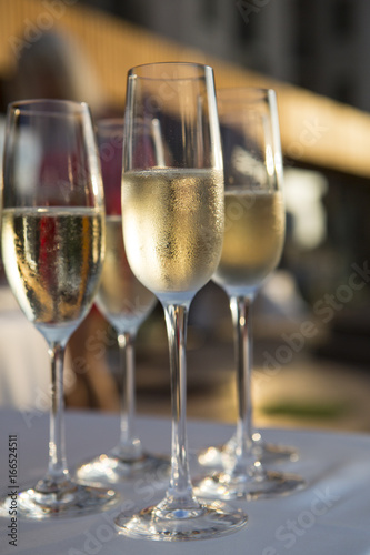 A lot of wine glasses with a cool delicious champagne or white wine at the bar. Alcohol background. lot of glasses with champagne during on the party table.