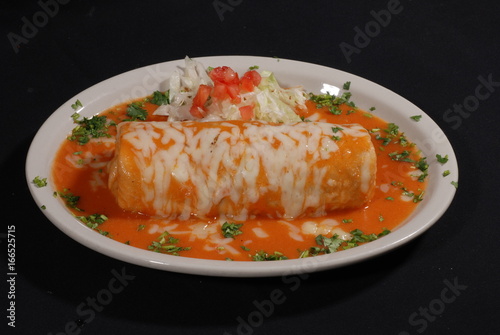 Wet burrito with cheese in red sauce. Burrito mojado