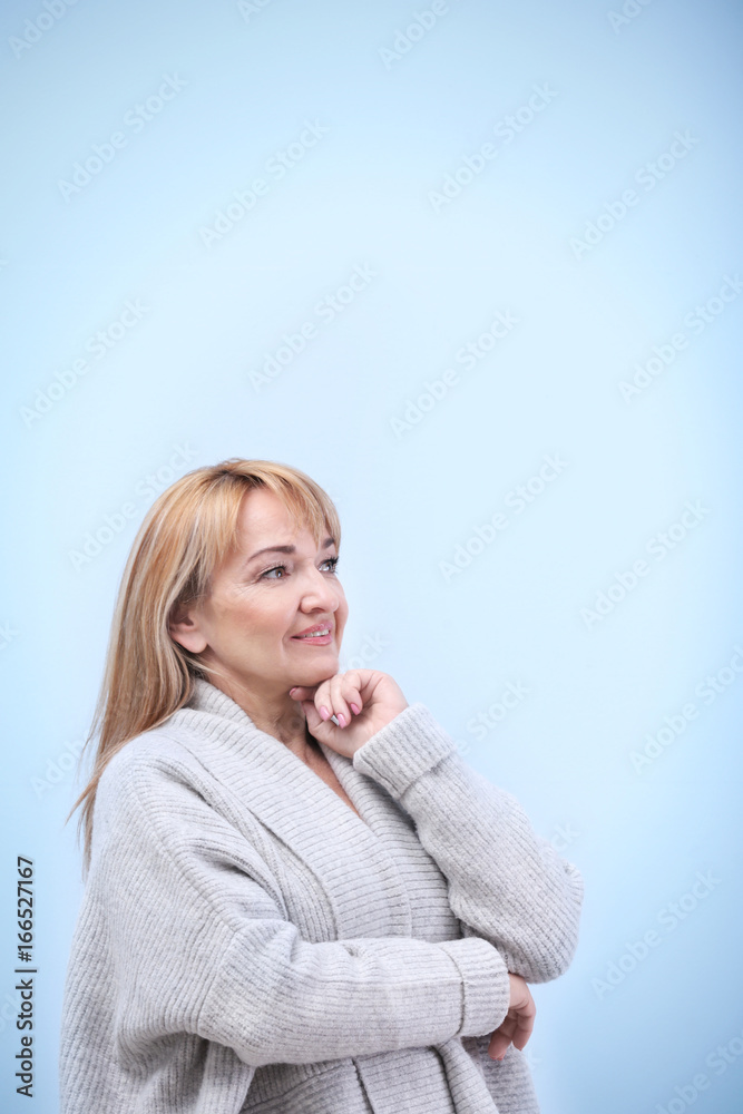 Portrait of mature woman on light blue background Portrait of mature woman on light blue background