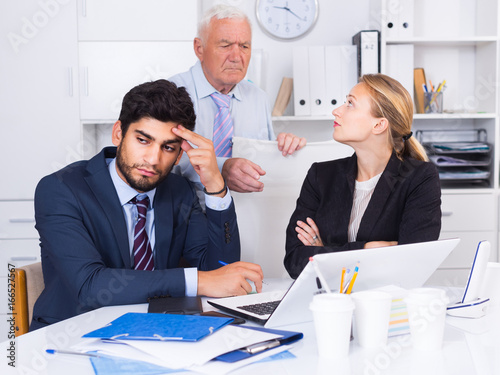 Fototapeta Mature boss is chastising employees because of uncompleted work