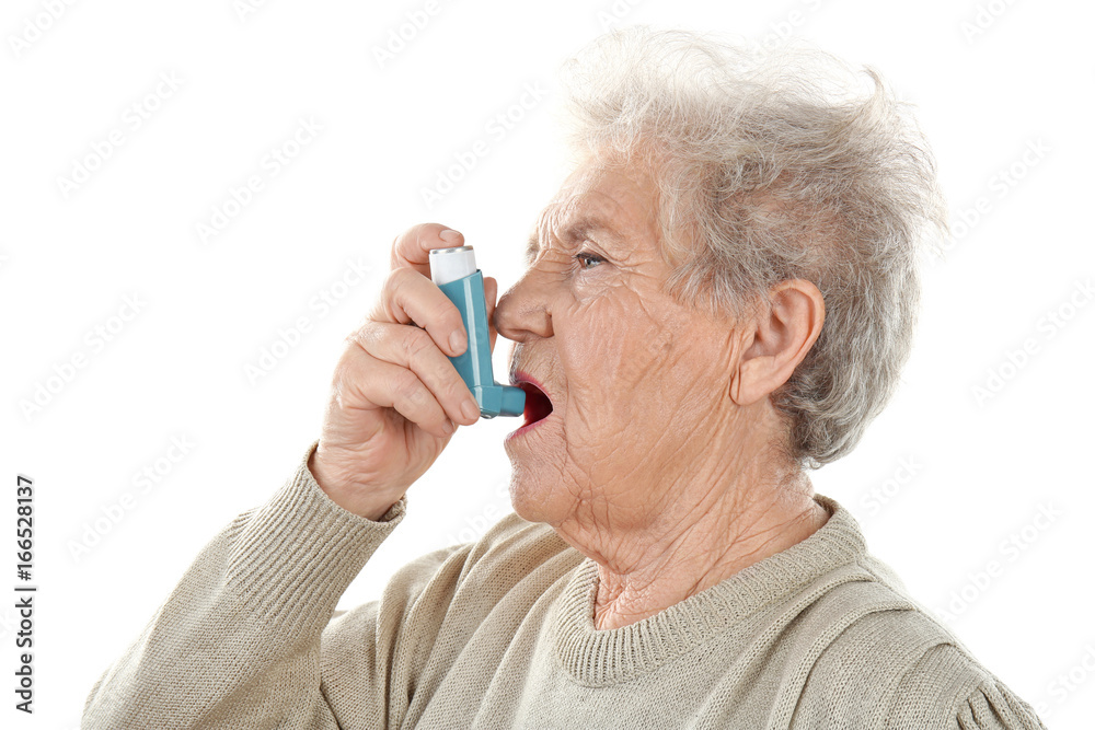 Elderly woman using inhaler during asthmatic attack on white background Elderly woman using inhaler during asthmatic attack on white background