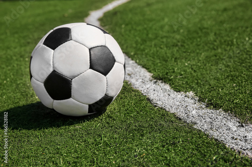 Soccer ball on fresh green grass outdoors