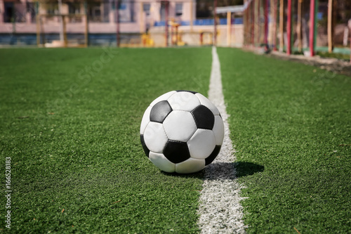 Soccer ball on fresh green grass outdoors © Africa Studio