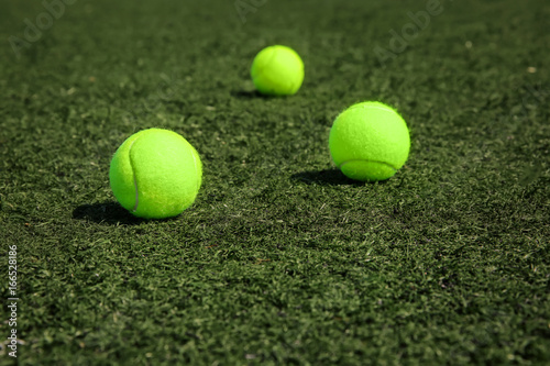 Tennis balls on fresh green grass outdoors © Africa Studio