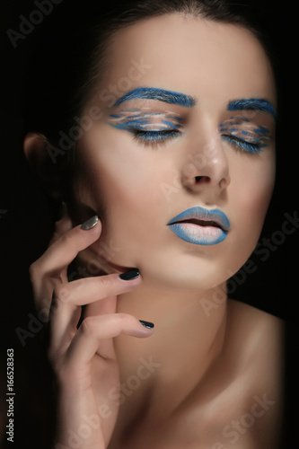 Beautiful young woman with creative make up on black background  closeup