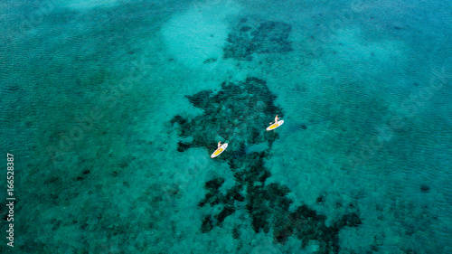 Aerial view of stand up paddleboards over a tropical coral reef