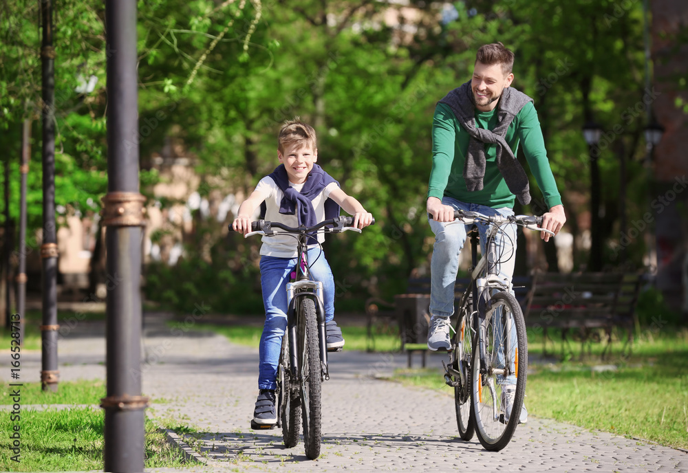 Dad and son riding bicycles outdoors