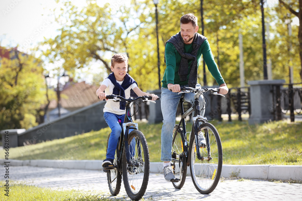 Dad and son riding bicycles outdoors