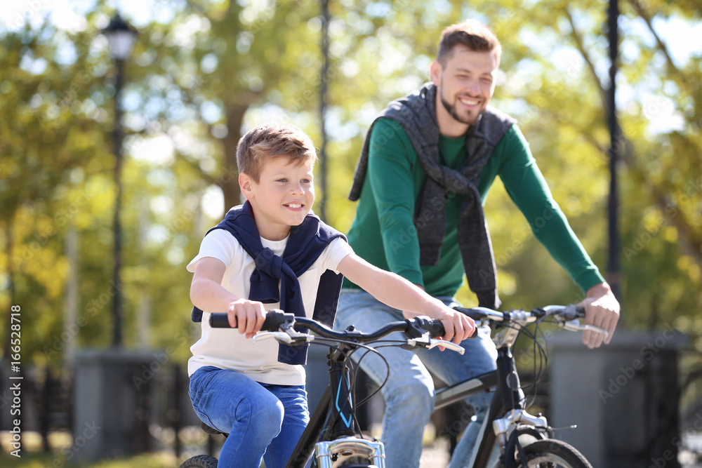 Dad and son riding bicycles outdoors