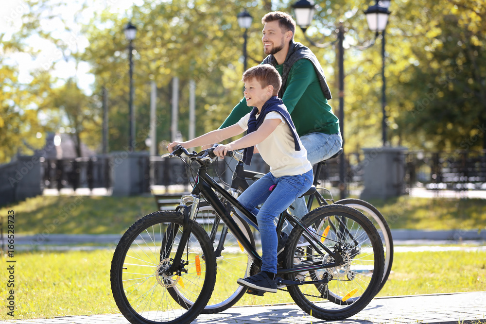 Dad and son riding bicycles outdoors