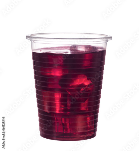 Red berry fruit drink in plastic cup, isolated on white. With ice.