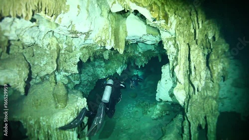 Scuba divers swim in Cenote Dos Ojos cave system