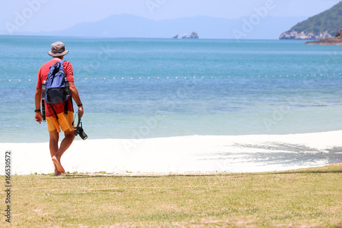 Tourist man with camera on coconut beach