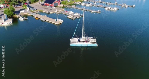 Catamaran, Cinema 4k aerial orbit view around a catamaran yacht, on a sunny evening dawn, outside a harbour, near Tammisaaren kansallispuisto national park, in Raasepori, Uusimaa, Finland photo