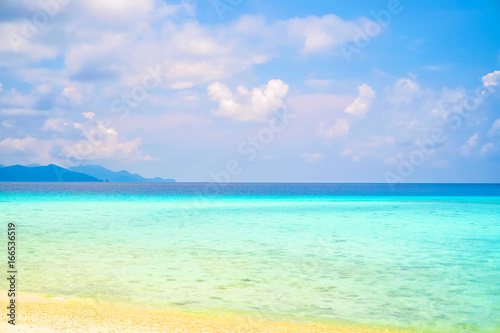 Beautiful white clouds on blue sky over calm sea with sunlight reflection, Tranquil sea harmony of calm water surface. Vibrant sea with clouds on horizon