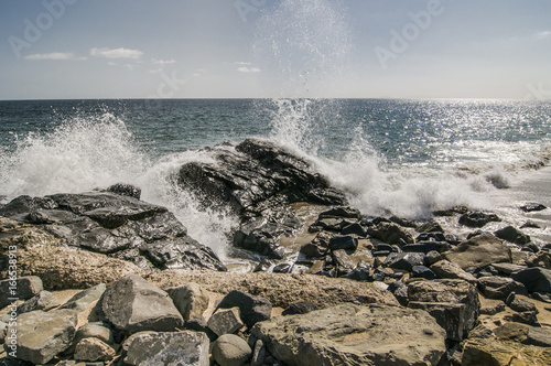 Waves crashing over rocks at Thornhill Broom beach in California photo