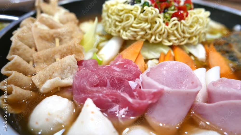 Korean Hot pot 'Budae Jjigae' or Army Stew is Korean fusion food incorporates American style with noodle, ham, sausages, canned baked beans, sliced cheese and Kimchi. Korean Hot pot 'Budae Jjigae' or Army Stew is Korean fusion food incorporates American style with noodle, ham, sausages, canned baked beans, sliced cheese and Kimchi.