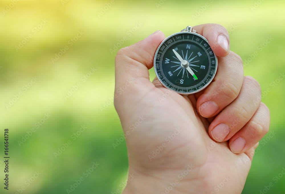 Compass in hand against nature landscape background. Compass in hand against nature landscape background.
