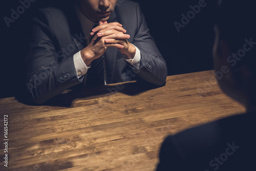 Detective interviewing suspect in dark room
