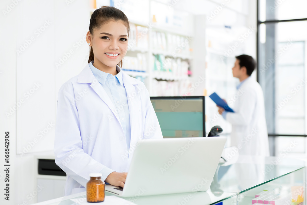 Smiling Asian female pharmacist working in pharmacy Smiling Asian female pharmacist working in pharmacy