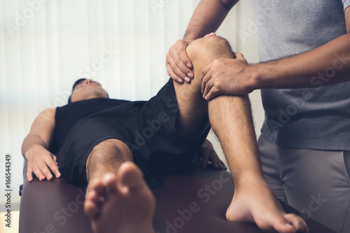 Fototapeta Naklejka Na Ścianę i Meble -  Physiotherapist treating athlete male patient