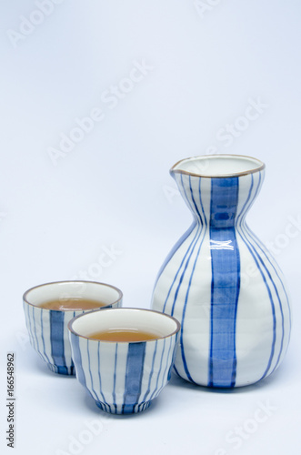 Sake bottle and cup on bright white background