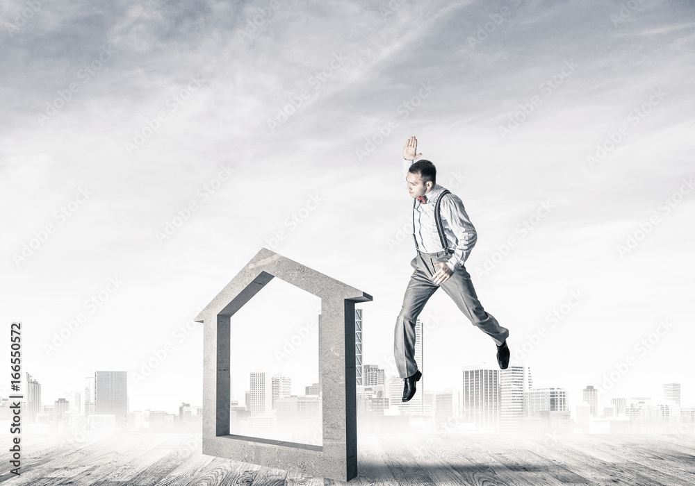 Manager man crashing stone home as symbol for real estate insura Manager man crashing stone home as symbol for real estate insura