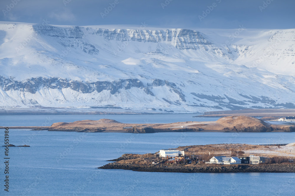 Icelandic coastal landscape. Snowy mountains