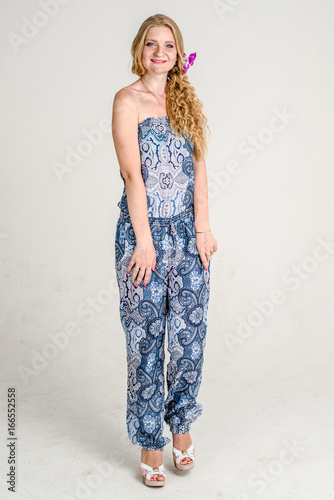 Beautiful romantic girl blonde in summer dress with orchid flower
