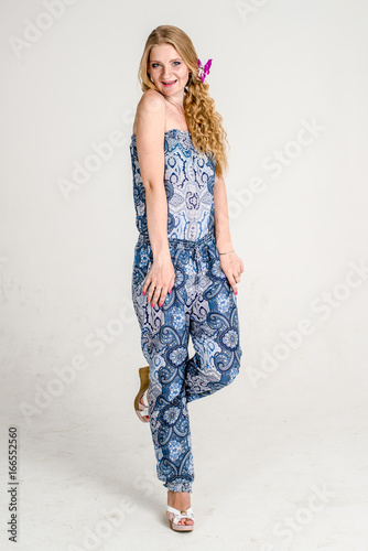 Beautiful romantic girl blonde in summer dress with orchid flower
