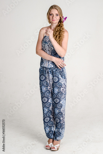 Beautiful romantic girl blonde in summer dress with orchid flower

