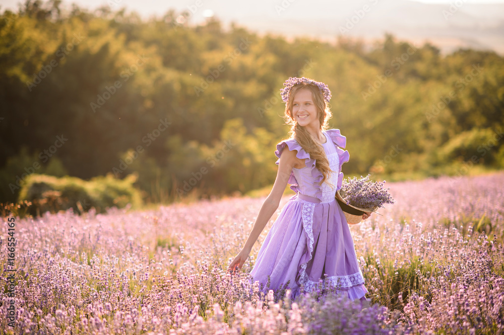 Beautiful girl in a field of lavender on sunset. Girl in amazing dress walk on the lavender field. Beautiful girl in a field of lavender on sunset. Girl in amazing dress walk on the lavender field.
