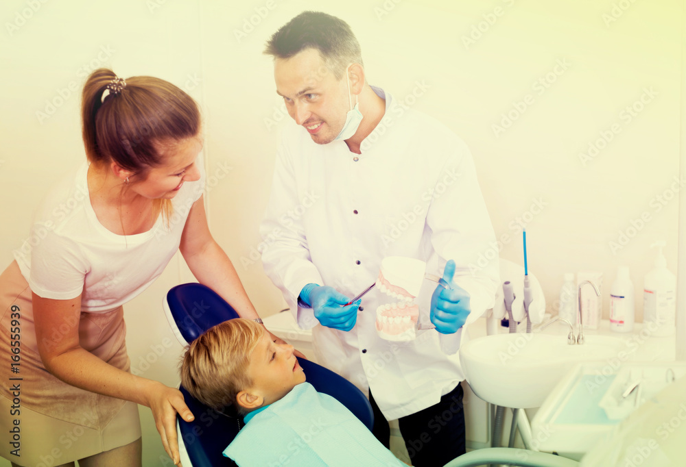 Fototapeta premium Professional in uniform is telling to young boy and mother about hygiene