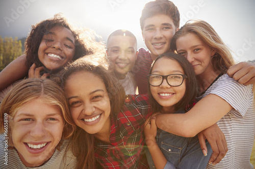 Teenage school friends smiling to camera, close up photo