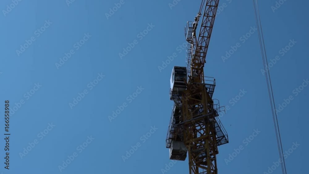 Construction Industry. Tower Crane Working Against Blue Sky Construction Industry. Tower Crane Working Against Blue Sky