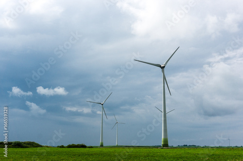 Wind Turbines and green fields on a cloudy day. Near storm