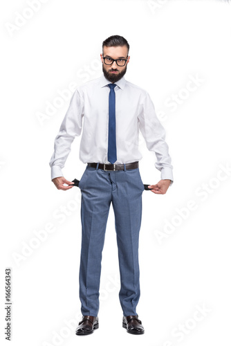 handsome poor businessman with empty pockets, isolated on white © LIGHTFIELD STUDIOS